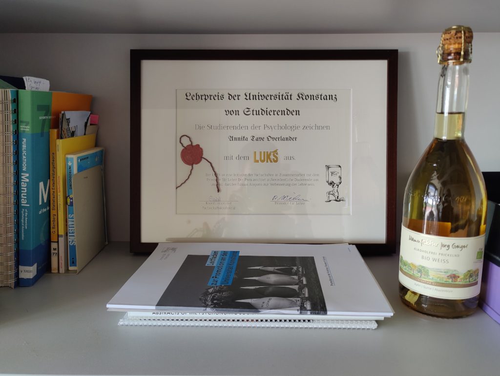 LUKS award in office shelf with books and non-alcoholic wine around